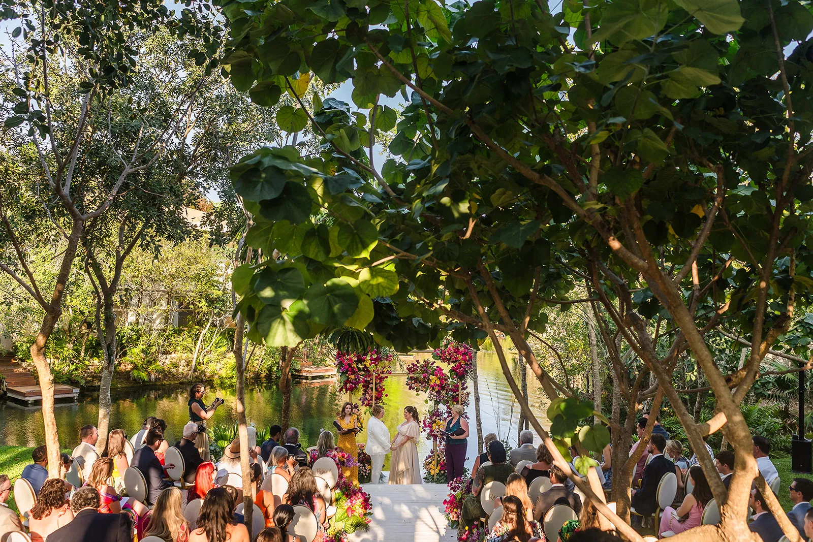 LGBTQ wedding ceremony at Rosewood Mayakoba with same-sex couple under lush tropical canopy in Riviera Maya Mexico