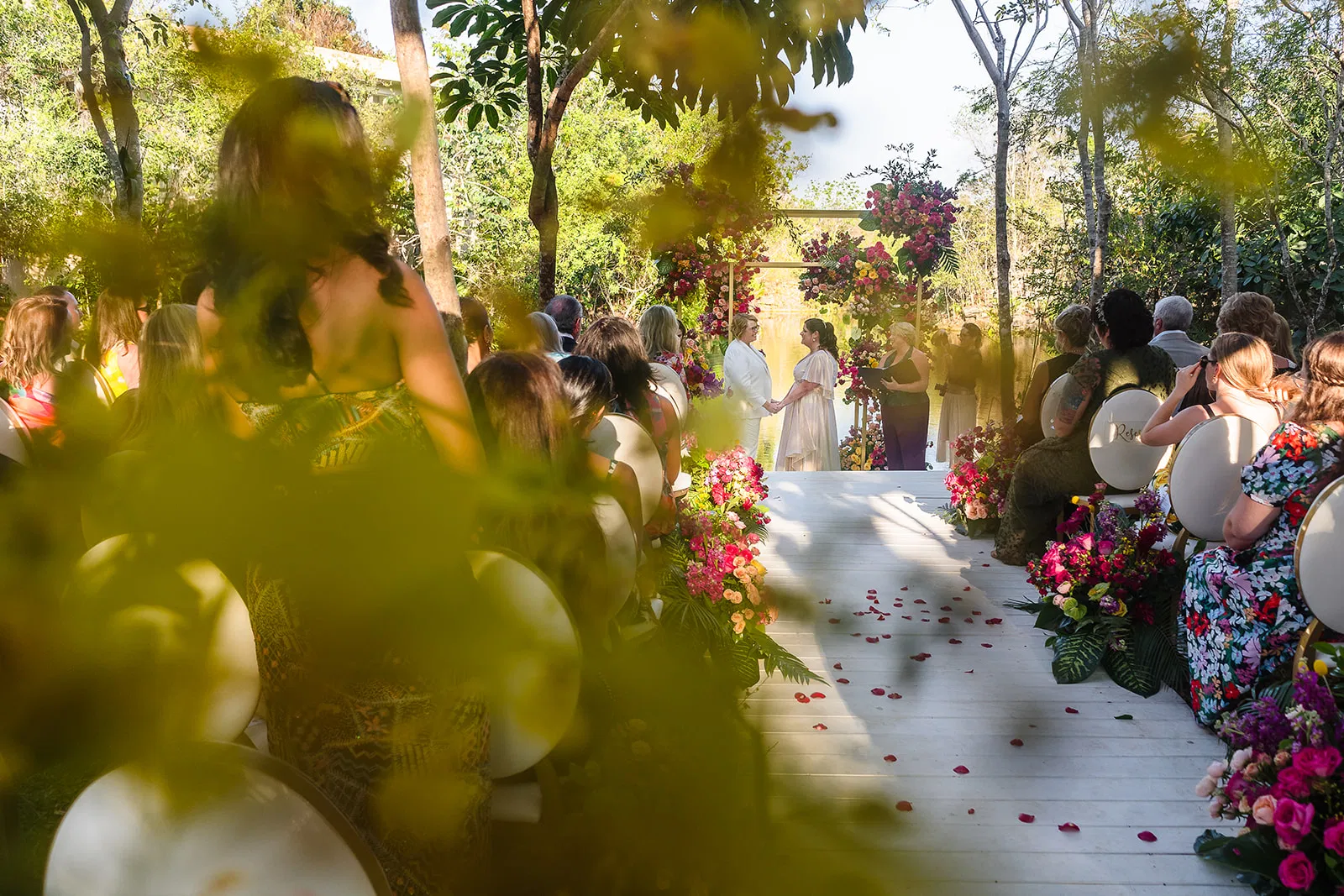LGBTQ wedding ceremony at Rosewood Mayakoba with same-sex couple exchanging vows among tropical flowers in Riviera Maya Mexico