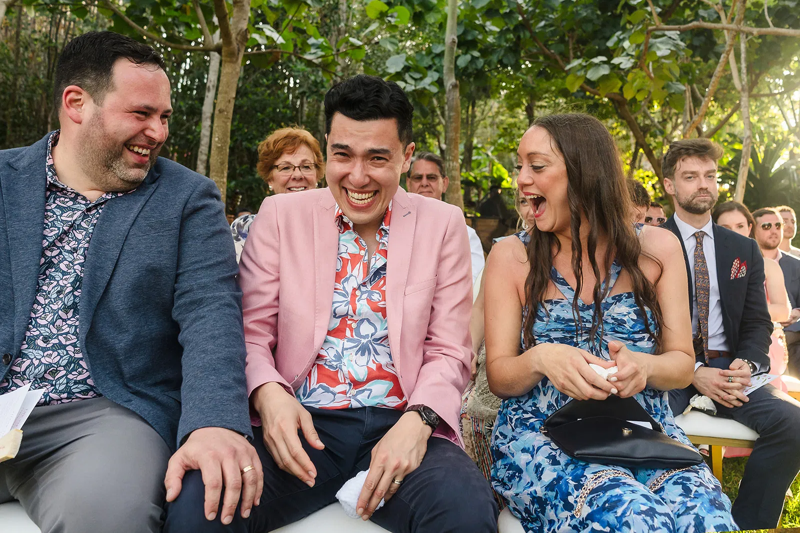 LGBTQ wedding guests laughing during same-sex ceremony at Rosewood Mayakoba, Riviera Maya Mexico destination wedding photography