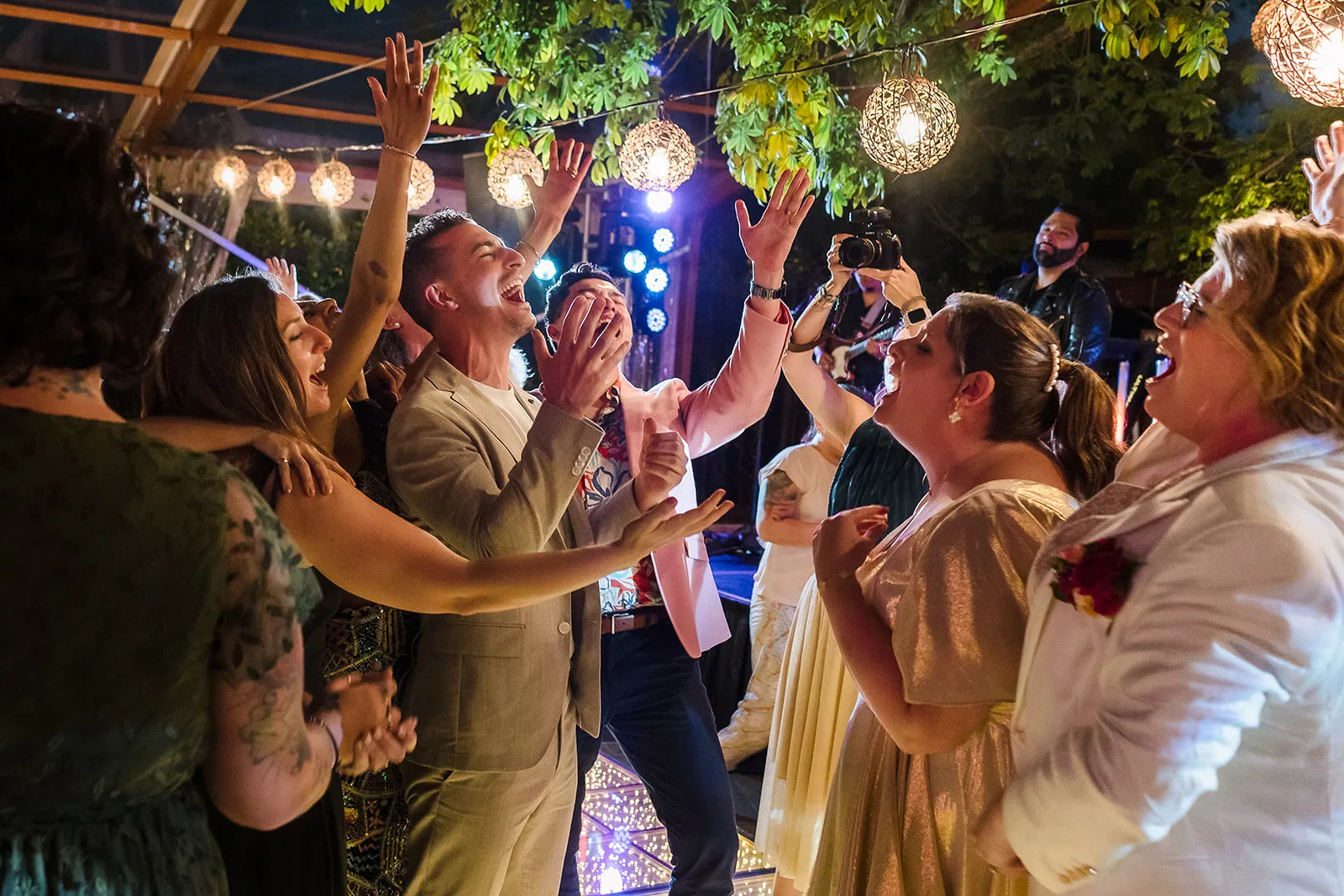 Gay wedding celebration at Rosewood Mayakoba with grooms and guests dancing under string lights in Riviera Maya Mexico