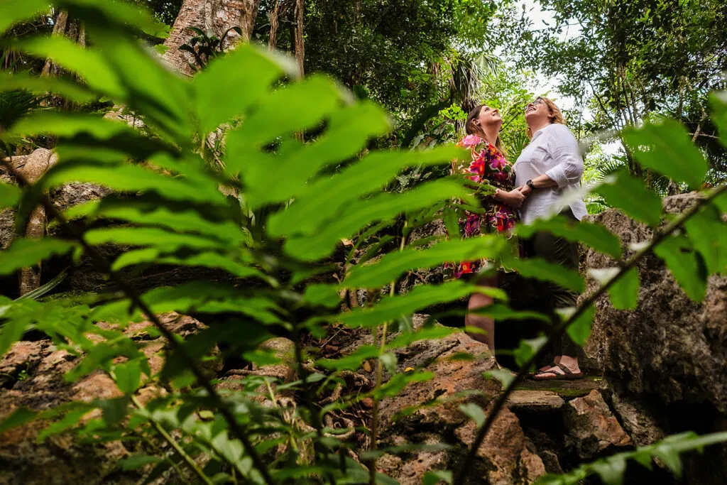 LGBTQ couple embracing in lush jungle setting at Rosewood Mayakoba, Riviera Maya - same sex wedding photography in Mexico