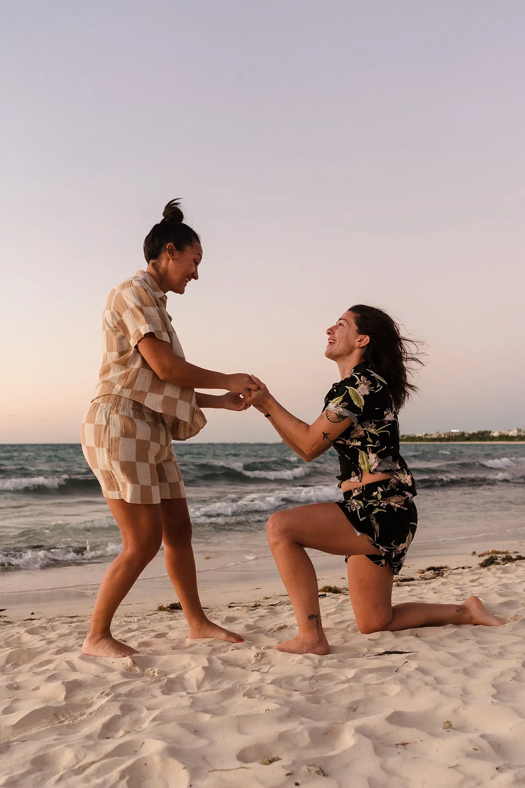 Surprise beach proposal in Cancun - two women embracing after a proposal by Tam Rico Photo