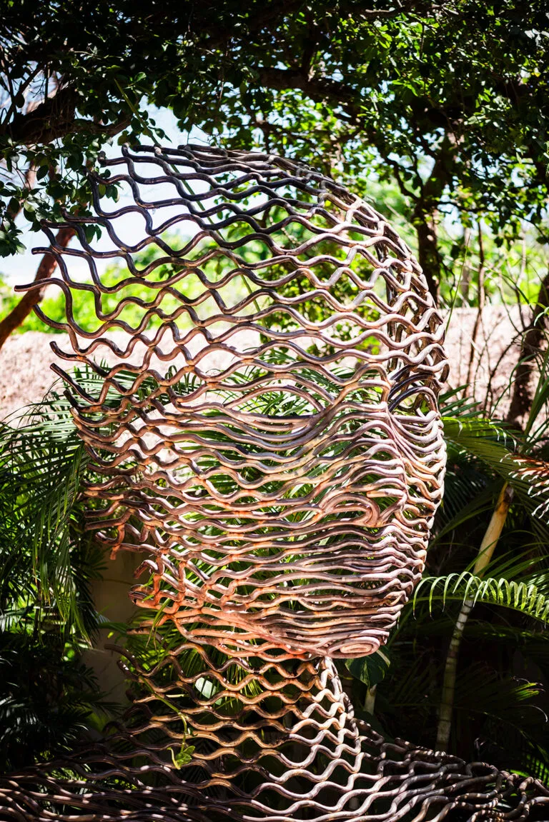 Modern art sculpture in lush Tulum jungle - unique backdrop for destination wedding photography in Mexico's tropical paradise