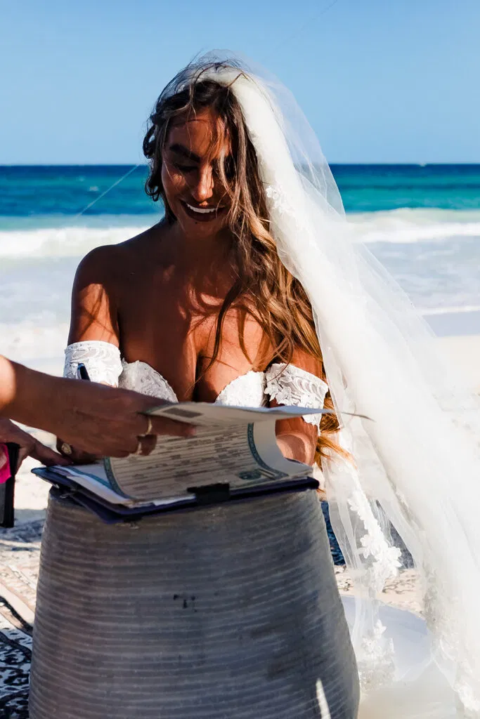 Bride reading vows on pristine Tulum beach wedding with turquoise Caribbean Sea backdrop in Mexico destination wedding