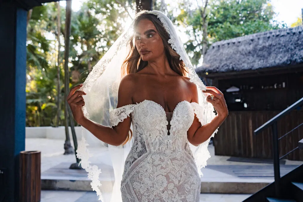 Bride in lace wedding dress with veil at luxury Tulum resort, tropical destination wedding photography Mexico