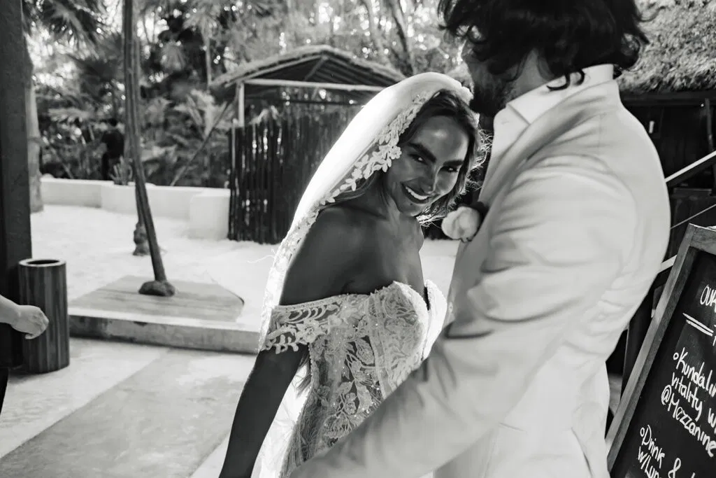 Bride and groom intimate moment at Tulum wedding ceremony with tropical jungle backdrop in black and white photography